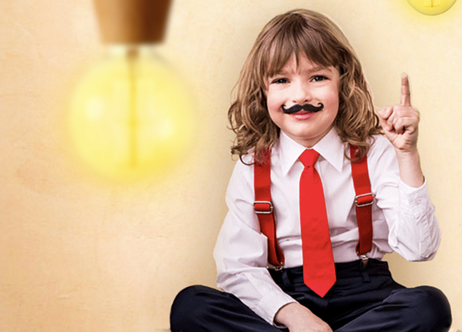 A child dressed playfully with a red tie and suspenders